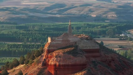 drone shot around top of hill with ruin and statue in spain