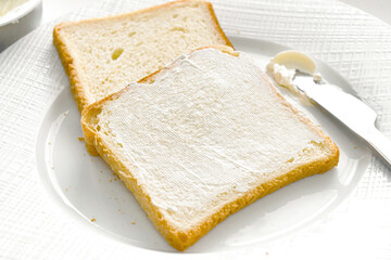 Bread slices with cream cheese on a plate.