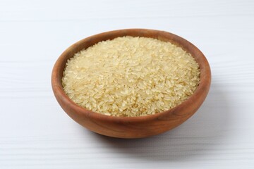 Raw brown rice in bowl on the table