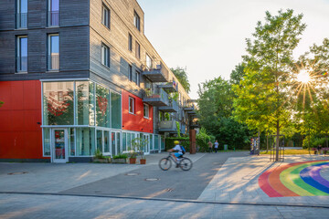 Modern apartment buildings in Munich with rainbow colors on asphalt and green community areas