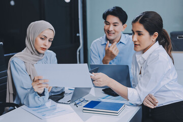 Diverse international executive business partners group discuss report at boardroom meeting table. Multiracial team negotiating project developing business strategy doing paperwork analysis in office.
