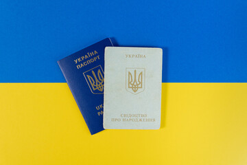 ukrainian passport and birth certificate on blue and yellow background, concept of identity, citizenship, and official documents