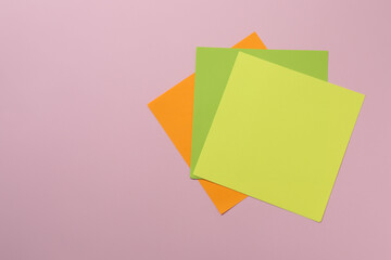 Multicolored paper stickers on a pink background