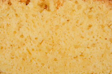 A detailed close-up shows the porous texture of a slice of yellow lemon cake