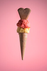 Strawberry and almond gelato cone with waffle heart on pink background