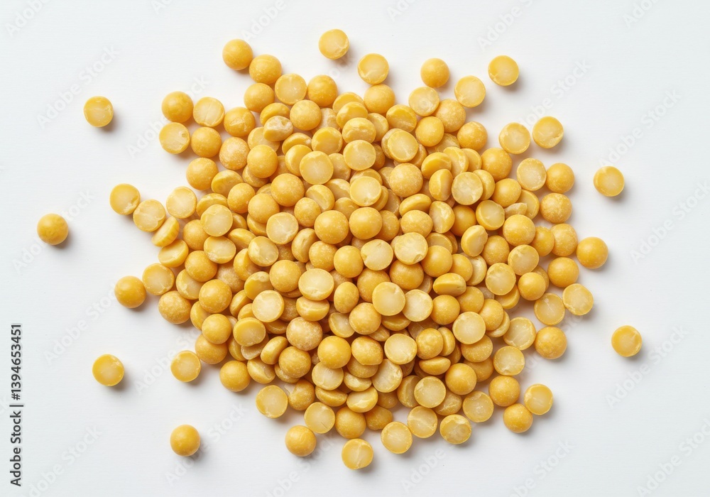 Poster a top down view of a pile of dried yellow split peas on a white surface in a studio setting