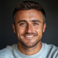 Fototapeta premium A man with a smile on his face is wearing a gray shirt