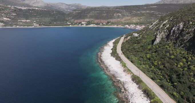 Aerial pan up of road leading to coastal town of Limeni, Greece on the Mani Peninsula Peloponeese region.