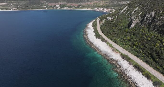 Wide aerial fly towards town of Limeni, Greece on a sunny spring day in the Peloponeese.