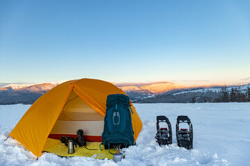 Overnight in a tent in the mountains in winter, camping equipment.
