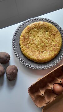Spanish Tortilla with Potatoes and Eggs on a White Kitchen Table