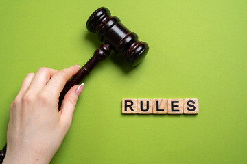 Judge's gavel and the word Rules in blocks. Law, justice, legal authority, courtroom decisions, and...