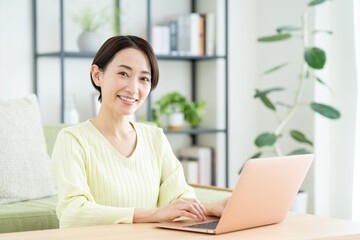 リビングでパソコンを使うミドルの女性