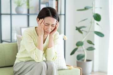リビングで悩むミドルの女性