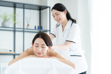 Fototapeta premium エステでマッサージを受けるミドルの女性