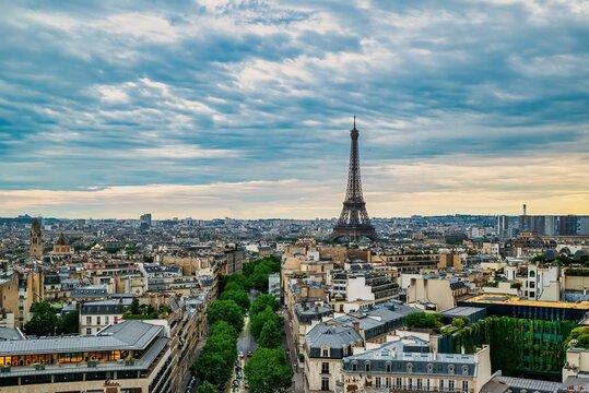 Paris cityscape with Eiffel Tower and dramatic sky. - Powered by Adobe