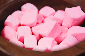 Pink marshmallows close up bokeh view in a wooden bowl