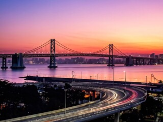 Fototapeta premium Sunrise Over a Bridge and Cityscape