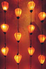 Glowing orange lanterns creating warm decorative background, Vertical hanging lanterns forming ambient light pattern