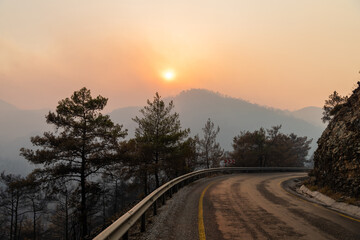 Sun shining through a cloud of smoke on Icmeler-Hisaronu road, following forest fires of July-August 2021 in Marmaris resort town of Turkey