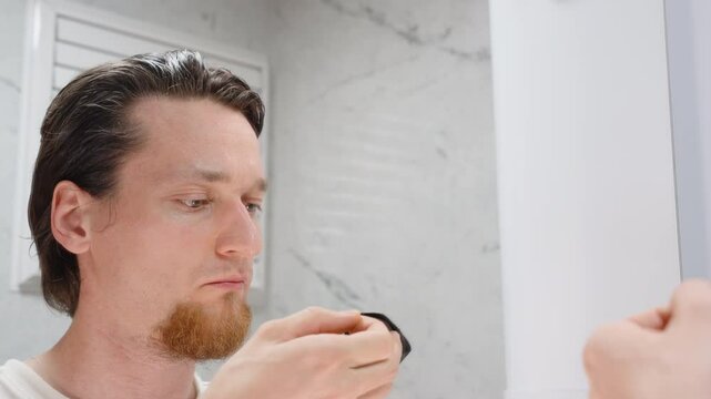 Man Looking in Mirror Applying Black Mouth Tape to Lips Before Sleep with Both Hands in Close-Up View for Better Nasal Breathing Concept