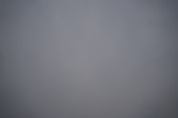 A serene, overcast sky with soft gray tones and a gentle gradient, offering tranquility and depth....