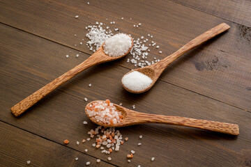 Different kind of sea salt in wooden spoon, close up. Salt for spa, salt baths or cooking