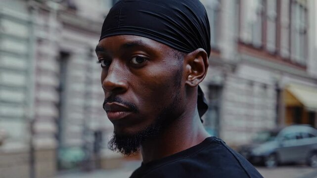 Contemplative Black man with durag against architectural urban backdrop