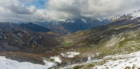 Mountain landscape of a valley on a cloudy day with a village in the depths of it