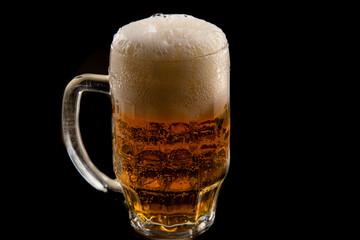 Half a litre of beer on black background. A glass of Pilsner beer