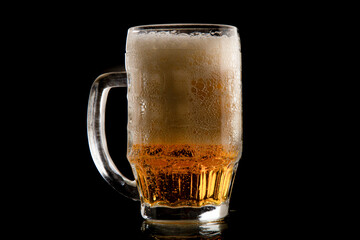 Half a litre of beer on black background. A glass of Pilsner beer