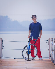 Handsome young man in a blue shirt and red sports long is happily and relaxing on a morning...