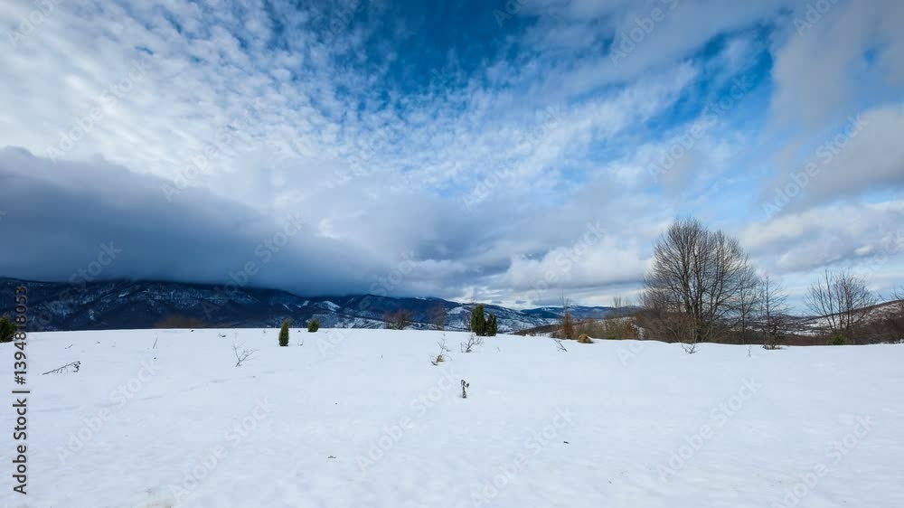 Poster a snowy field is set against a backdrop of mountains and a dynamic sky filled with clouds. winter ti