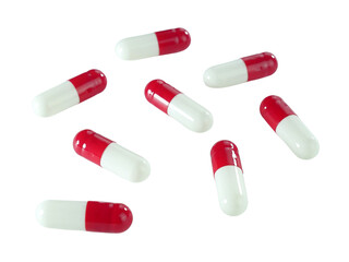 Bulk red and white capsule pills isolated on white background.