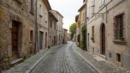 Fototapeta premium Narrow cobblestone street lined with historic buildings in a quaint village.