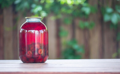 glass jar with plum compote on the table