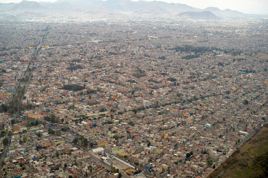 Aerial view of a sprawling urban landscape with dense housing and distant mountains. Mexico City, Mexico