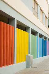 Vertical shot of multi colored painted concrete bars on a building, street photography