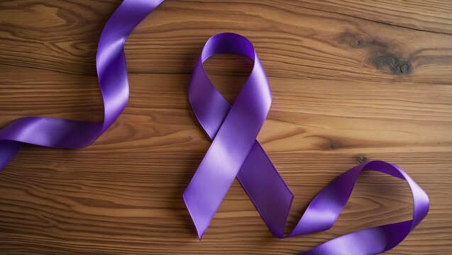 Purple ribbon awareness featured on a wooden background with copy space available. This symbol is aimed at raising awareness for those affected by cancer, epilepsy, lupus, Alzheimer's disease, and