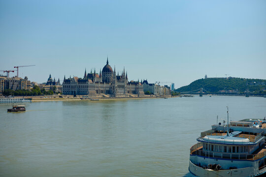 Budapest Parliament across the Danube River with boats and distant hills in view. Prague, Czech Republic