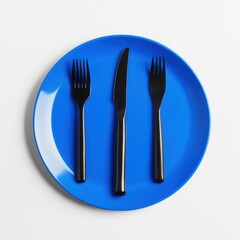 Black utensils on a blue plate against a white background studio on isoleted white background