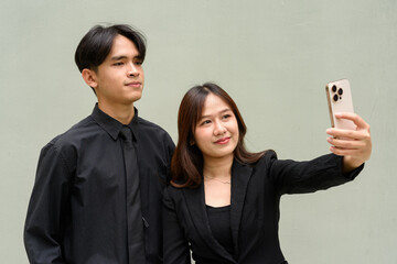 Portrait of young Asian couple wearing business uniform