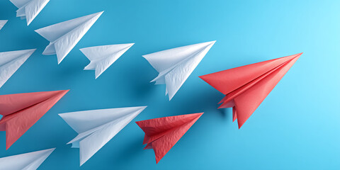 Fototapeta premium Red and white paper airplanes on blue background, showcasing leadership and standing out from the crowd concept. Free space for text