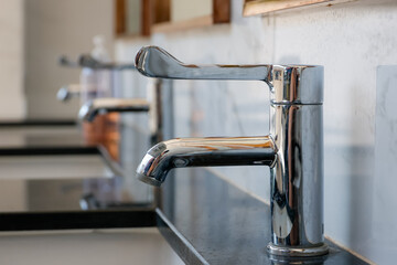 sleek chrome faucet installed on a polished black marble counter