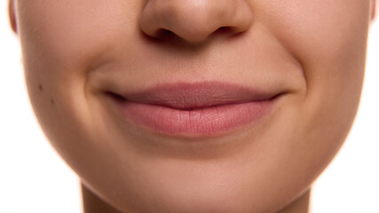Extremely close up of female face with well-kept healthy skin, and plump, moisturized, pink lips...