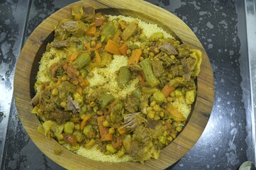 Moroccan Couscous in a wooden plate (Kasaa), with beef meat and vegetables