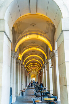 Looking down a row of lighted archways and pillars in a cafe