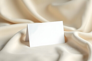 Elegant blank card resting on luxurious silk fabric, ideal for showcasing personalized messages, branding or invitation mockups with a touch of sophistication