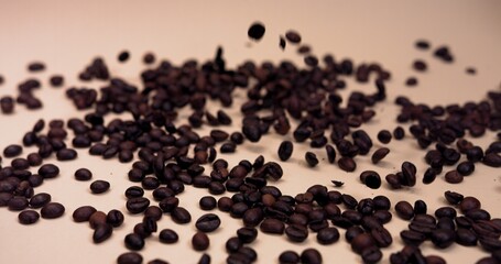 Coffee beans fall on the table, bouncing and scattering in slow motion