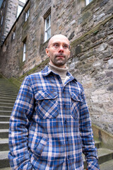 young traveler man explores medieval streets Edinburgh, ancient alleys, discovery archipelago...
